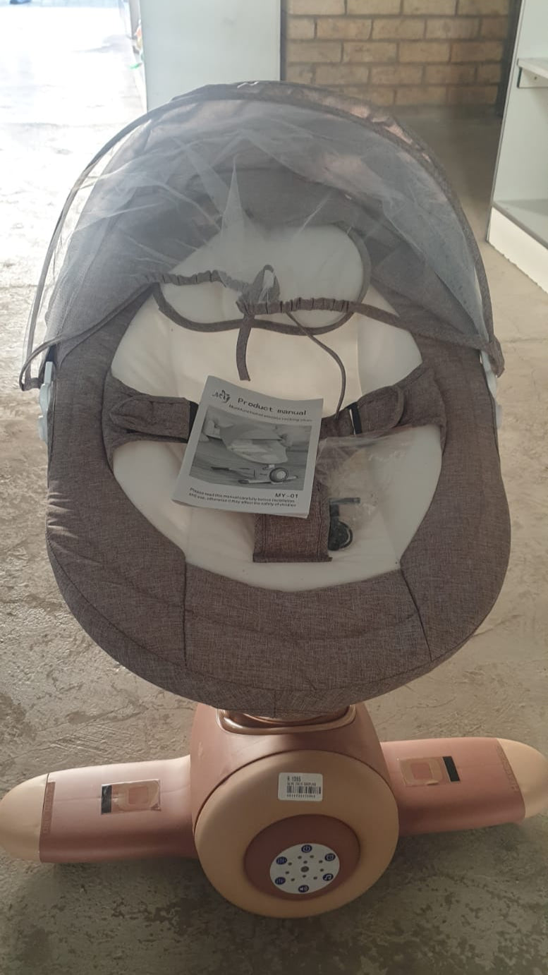 Baby swing chair with canopy on a white rug in a room with striped wallpaper